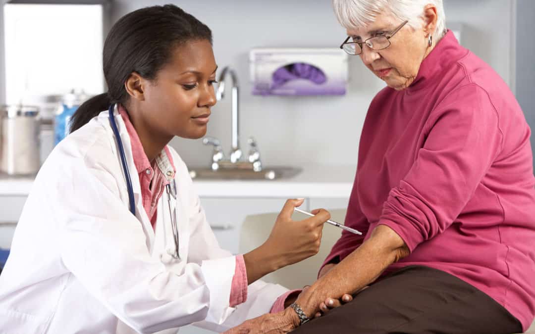 Doctor Giving Senior Female Patient Injection Concentrating
