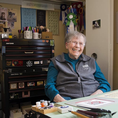 Older Women smiling with Calligraphy items around her