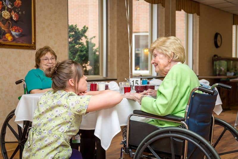 Nurse talking to two elderly ladies