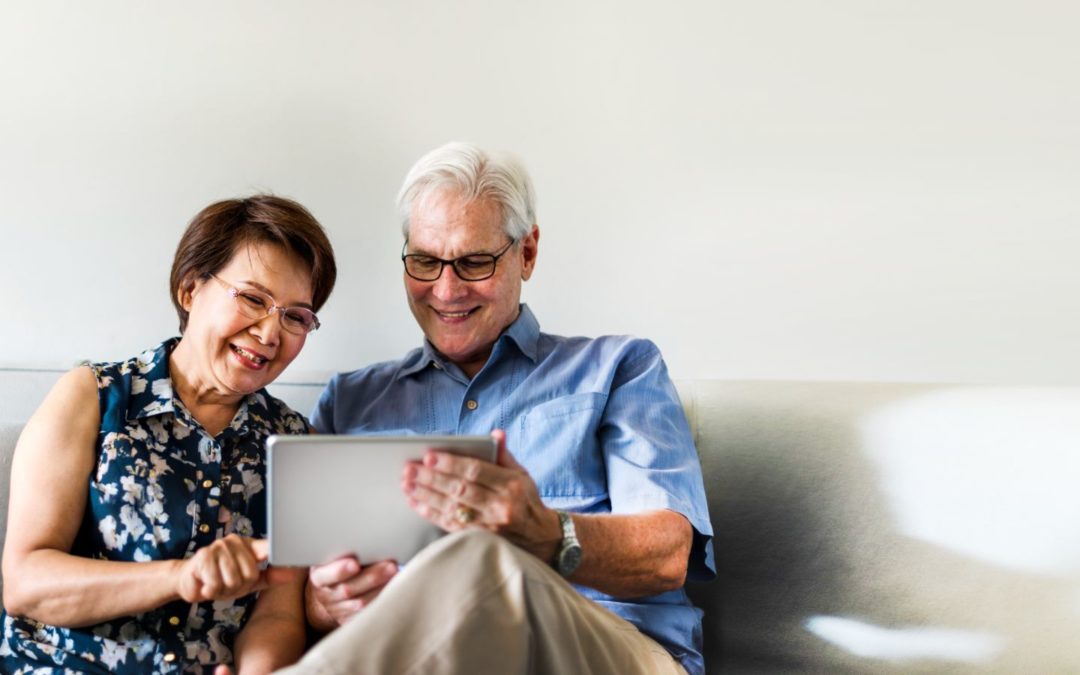 A senior couple using a digital tablet in a living room.