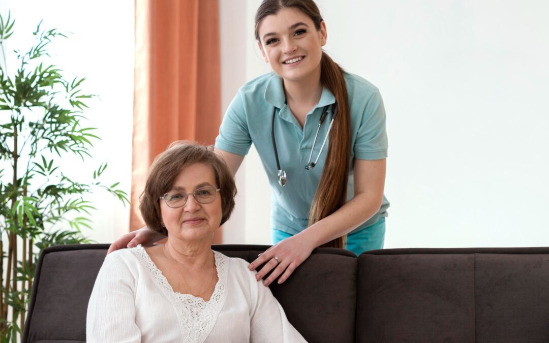 A nurse and an older woman smile and pose for a photo.