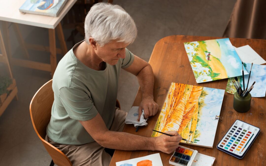 An older man painting a watercolor picture.