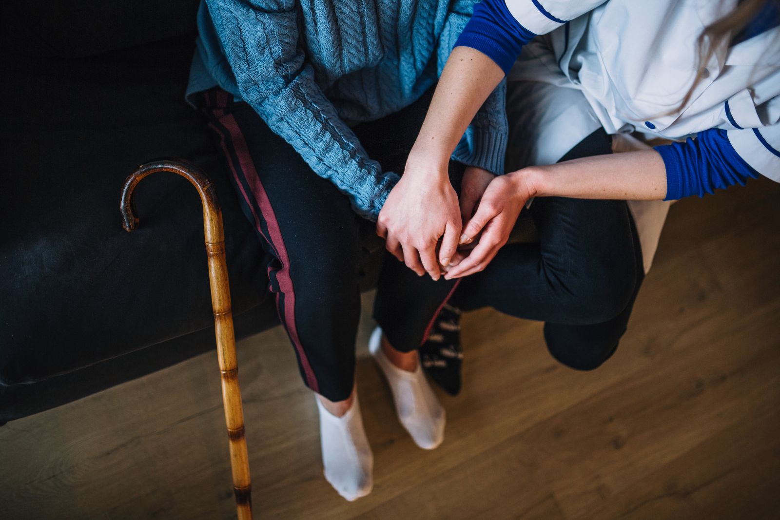 A nurse holding hands with a senior woman.