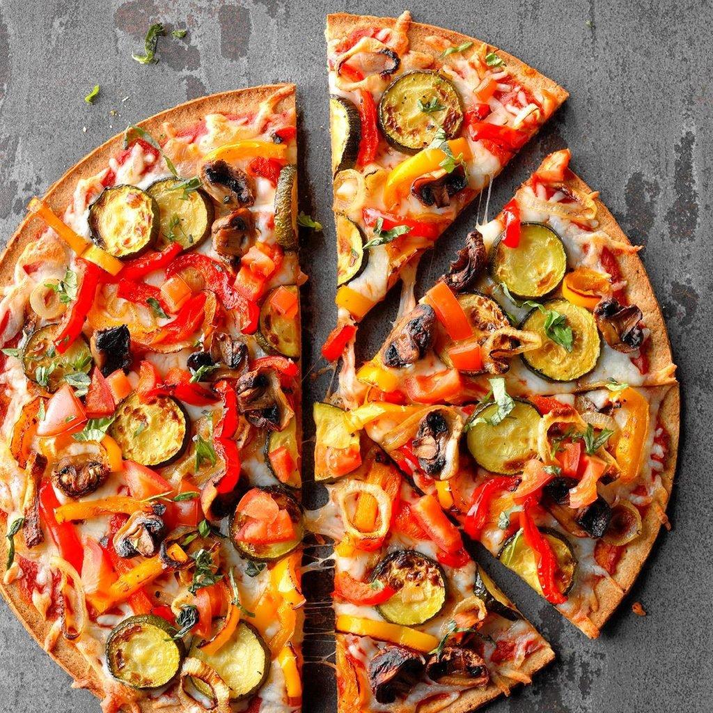 A large Vegetable Pizza thats been split in half